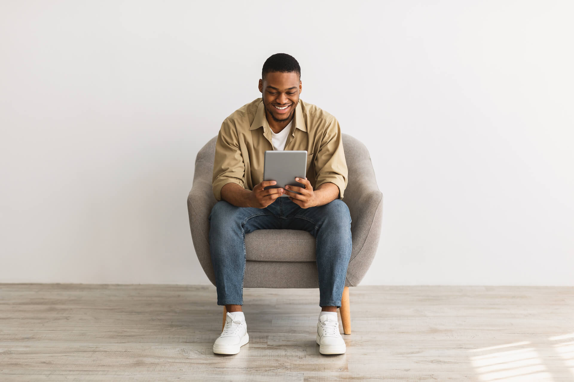 happy-african-man-using-digital-tablet-sitting-ove-2021-09-02-17-14-23-utc.jpg
